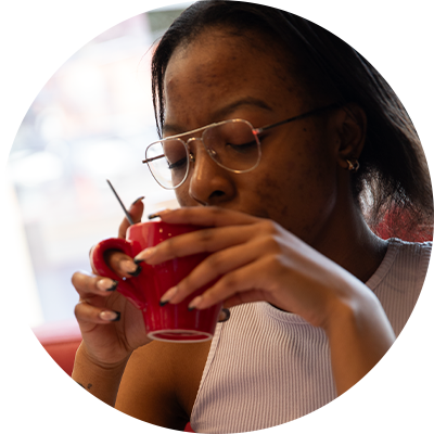 Lady drinking coffee from a red mug