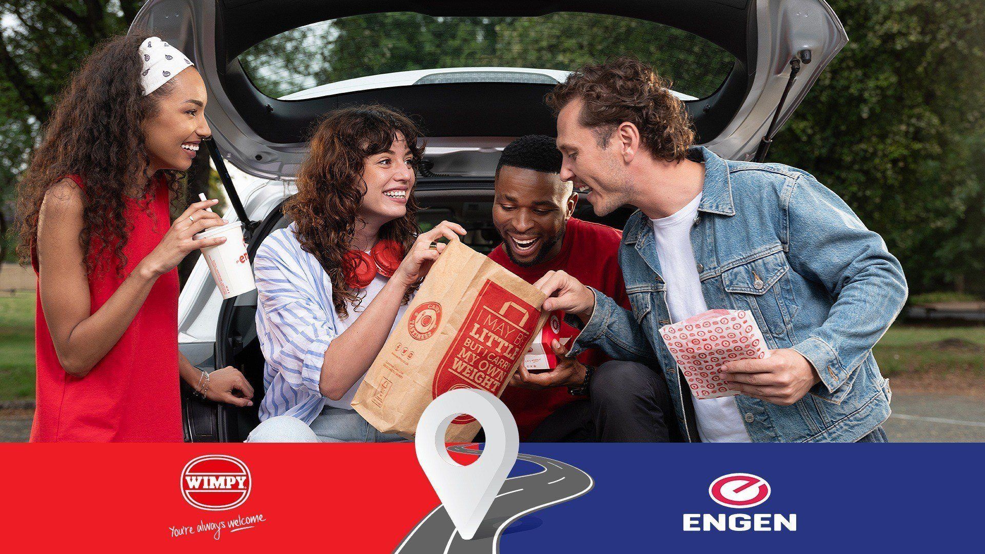 People standing outside a car looking into Wimpy takeaway bag